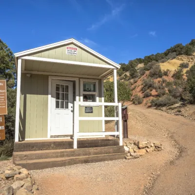 a house that has a sign on a dirt road