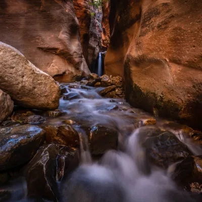 a large waterfall next to a rock