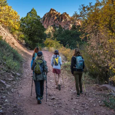 a group of people walking down a dirt road